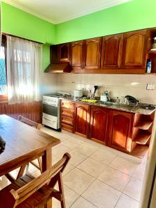 a kitchen with wooden cabinets and a table and a stove at Casa Kime in Tortuguitas