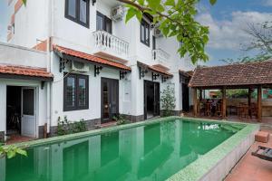 a house with a swimming pool in front of it at Hoi An Blue River Hotel in Hoi An