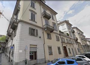 um edifício com um carro azul estacionado em frente dele em Turin Central Suite em Turim