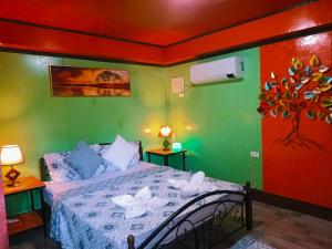 a bedroom with a bed in a room with green at Adrianas Place Backpackers Hostel in Panglao Island