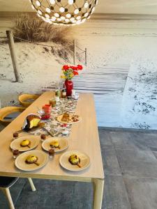 una mesa de madera con platos de comida. en Maison HOUX en Dominois
