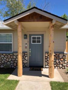uma casa com uma porta azul e uma parede de pedra em Riverside Cabin 3 em Grants Pass