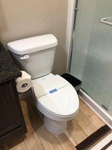 W łazience znajduje się biała toaleta i prysznic. w obiekcie Riverside Cabin 3 w mieście Grants Pass