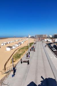 une rue avec des personnes assises sur des bancs sur la plage dans l'établissement Les Hortensias, à Sangatte