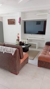 ein Wohnzimmer mit 2 Sofas und einem Flachbild-TV in der Unterkunft la casa hermosa in Quito