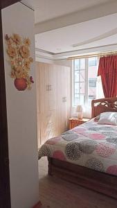 um quarto com uma cama e uma janela em la casa hermosa em Quito