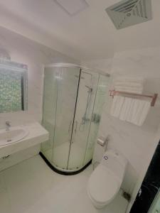 a bathroom with a shower and a toilet and a sink at Bài Thơ Mountain Hotel in Ha Long