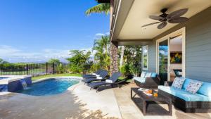 a patio with chairs and a swimming pool at HEAVENLY DAYS Stunning Views from KaMilo 3BR Home with Heated Pool in Waikoloa