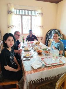 a group of people sitting around a table eating food at Sunil's Homestay Sinharaja in Kalawana