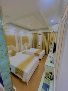 a hotel room with two beds and a desk at Bài Thơ Mountain Hotel in Ha Long