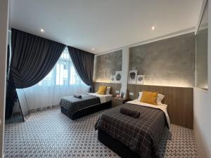 um quarto de hotel com duas camas e uma janela em Ninety Guest House em Ipoh