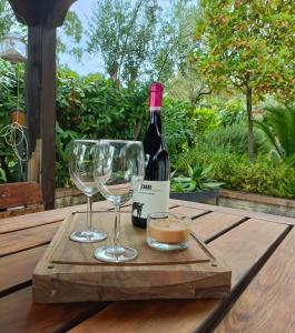 Una botella de vino y dos copas en una mesa de madera. en Villa Teresa - Appartamento La Taverna Cilento - Ceraso, en Ceraso