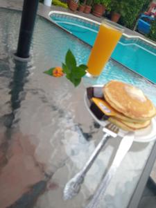 a table with pancakes and a glass of orange juice at Hotel Parador del Rey in Temixco