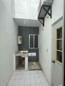 een witte badkamer met een wastafel en een raam bij Departamento por plaza terraza oblatos in Guadalajara