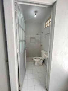 een witte badkamer met een toilet en een wastafel bij Departamento por plaza terraza oblatos in Guadalajara