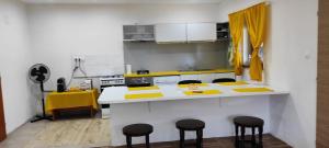 a kitchen with a yellow and white counter and stools at AG Studio Apartment in Gabčíkovo in Gabčíkovo