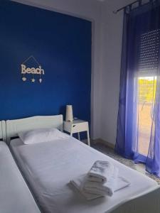 a bedroom with a bed with a blue wall at Meerithic ROKKA ROOMS in Vourvourou