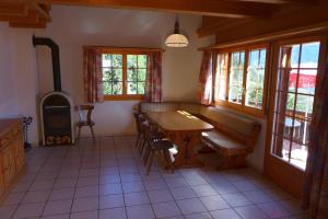 comedor con mesa, sillas y ventanas en Wohnung mit 4 Schlafzimmer, en Guttet-Feschel