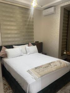 a bedroom with a large bed with white sheets and pillows at L'horizon Aéroport Appartement in Marrakech