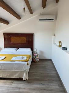 twee bedden in een kamer met witte muren en houten vloeren bij Mondello Apartment in Mondello