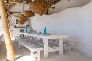 a white table with benches in a room at Gravity Eco Boutique Hotel - Adults Only in Uluwatu