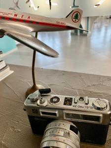 a model airplane sitting on a table with a camera at L'Hotel De Mon Pere in Jbeil