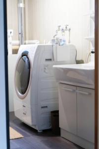 a large white machine in a bathroom with a sink at 一棟貸宿　奥入瀬屋 in Yakeyama
