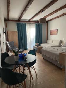 een slaapkamer met een bed en een tafel en stoelen bij Giasemi apartments in Karistos