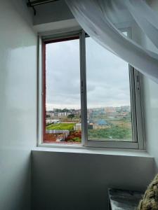 una ventana en una habitación blanca con vistas en Omuts one bed airbnb with swimmingpool en Kiambu