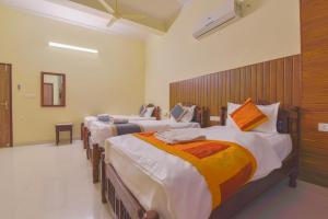 pokój z czterema łóżkami z rzędu w pokoju w obiekcie Jaipur Nobel w mieście Dżajpur