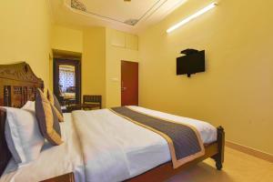 1 dormitorio con 1 cama y TV en la pared en Jaipur Nobel, en Jaipur