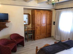 1 dormitorio con cama, silla y escritorio en Hotel Paradiso, en Asiago