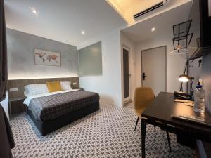 a bedroom with a bed and a desk in it at Ninety Guest House in Ipoh