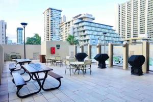 ホノルルにある28th Floor Breathtaking Ocean View with a Kitchen-Free Parking-Corner Unit-King Bedのテーブルと椅子とパラソルのあるパティオ