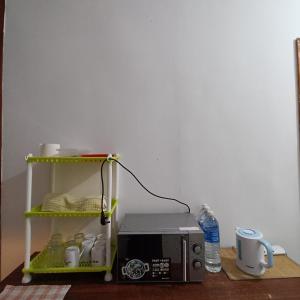 eine Mikrowelle auf einem Tisch neben einem Toaster in der Unterkunft Tabun Homestay in Miri