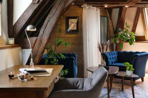 un bureau mansardé avec des chaises bleues et une table en bois dans l'établissement Suite Toussaint - Calme & Authentique, à Angers