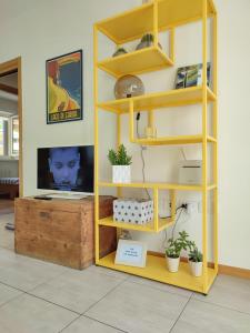 a yellow book shelf with a computer on it at L&G APARTAMENT in Nago-Torbole