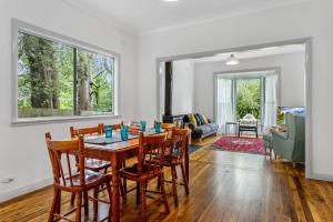 ein Esszimmer und ein Wohnzimmer mit Tisch und Stühlen in der Unterkunft Garden Cottage in Leura