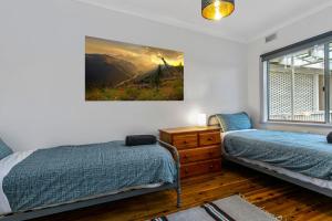 um quarto com duas camas e um quadro na parede em Garden Cottage em Leura