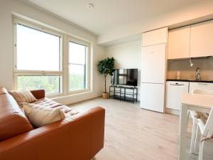 uma sala de estar com um sofá e uma cozinha em New studio apartment - next to Vuosaari metro and mall, self check-in em Helsinque