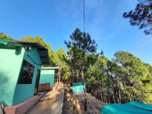 ランズドーンにあるRohini Village Homestayの青い建物のある森の中の道
