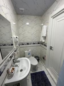 a white bathroom with a sink and a toilet at OLD STREET Guest House in Samarkand