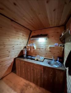 a bathroom with a sink in a wooden cabin at A frame for families in Quba