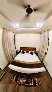 a bedroom with a large bed with curtains at Hotel Govindam Elite in Juhi Bari