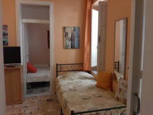 um pequeno quarto com uma cama e um espelho em Appartamenti Lascaris em Lascari