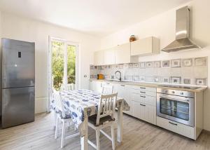 a kitchen with a table with chairs and a refrigerator at Gelso in Marciana