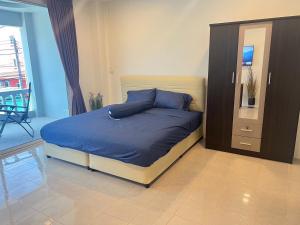 a bedroom with a bed with blue sheets and a dresser at AB House in Ban Thung Thong
