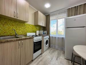 uma cozinha com um lavatório, um fogão e uma máquina de lavar louça em Маг Подарки, Конституции, парк, Рахмет em Petropavl