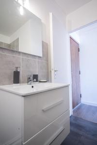 a white bathroom with a sink and a mirror at SWEETHOME DIJON - ALBERT 1er in Dijon