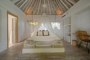 a bedroom with a bed with a mosquito net at Gravity Eco Boutique Hotel - Adults Only in Uluwatu